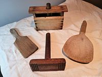 Butter mould and three wooden paddles displayed on a cloth background