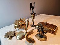 Overview of all six brass items together on a white cloth background.