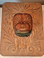Front view of wooden wall art showing the detailed carved dog head and floral ornamental background.