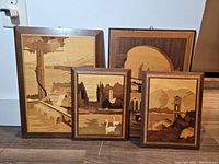 Four framed handmade wood parquet landscape pictures arranged on the floor showing overall lot