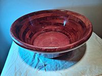 Side angle view showing the polished, multi-toned wood grain and rounded rim