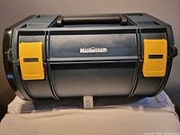 Front view of black toolbox with yellow latches and Mastercraft branding on front.