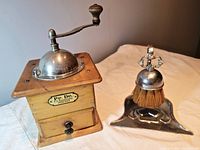 Front view of the wooden spice grinder and the crumb sweeper showing labels and overall condition.