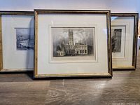 Three framed British landscape prints leaning against a wall, showing frames and artwork details.