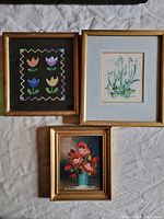 Set of three framed floral artworks including embroidered tulips, flower print, and oil painting of roses.