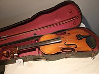 Full view of violin, bow and case inside open hard shell case