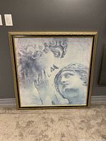 Full view of the framed canvas wall art showing the faces illustration.