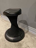 Side angle view of black Hula Chair showing contoured seat and stable base