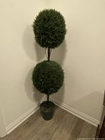 Full view of the artificial topiary tree showing two spherical foliage balls stacked vertically in a green pot.