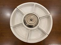 Rotating serving platter fully assembled with six white ceramic sections and metal center.