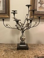 Front view of the metal multi-arm candelabra showing its branches, candle holders, and base.