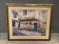 Front view of the framed wall art showing detailed painting of a European street with bicycle and flowers.