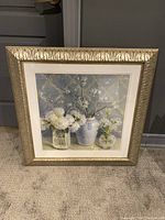 Framed floral wall print art showing full piece with decorative gold-toned frame and glass cover.