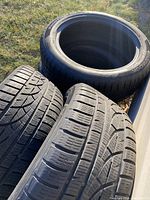 Four winter tires stacked and leaning, showing overall set
