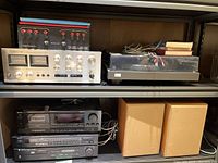 Overview of shelving with amplifier, turntable on top and stereo components with speakers below