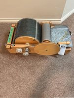 Front view showing wooden frame, large and small drums, metal tray and seller tag attached.