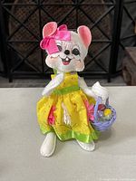 Front view of Annalee Easter collectible mouse doll dressed in yellow holding basket with Easter eggs