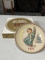Front view of 1971 M.J. Hummel angel plate on original box
