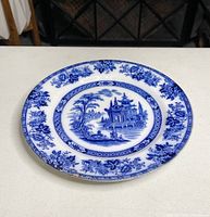 Front view of blue and white decorative plate with pagoda and floral pattern