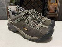 Pair of brown Keen women's size 8.5 sneakers with lace-up closure on tile floor