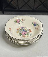 Stack of 4 Homer Laughlin Virginia Rose bowls showing floral pattern and scalloped silver trim edges.