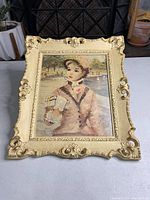 Full view of vintage framed textured print depicting a Victorian woman holding a fan in pastel clothing with ornate gold frame.