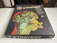 Top view of the vintage NFL National Football League Strategy board game box showing the colorful graphic of a football player with strategy markings.