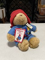 Front view of the plush Paddington Bear sitting upright with its 40th anniversary tag visible.