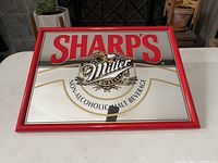 Full view of the rectangular vintage bar mirror sign with red frame showing text and logo.
