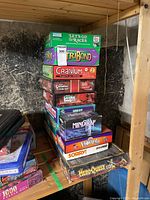 Stack of board games on wooden shelving in basement storage area