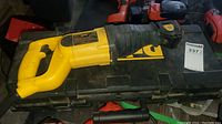 Side view of the entire yellow and black DeWalt reciprocating saw lying on a black DeWalt case.