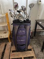 Purple and grey Taylormade golf bag holding multiple golf clubs showing the set arrangement and bag condition.