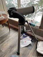 Three-quarter view of optical tube mounted on fork mount with tripod and hand controller visible.