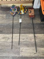 View of all 3 glass art stakes mounted on rods laid on floor showing full size and detail.