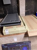 Photo showing the three pet ramps stacked on top of each other, with two beige textured ramps and a gray foldable ramp on top.