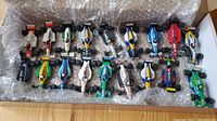 Twenty Onyx Formula 1 model race cars arranged in a box with bubble wrap, showing variety of colors and designs.