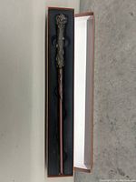 Replica wand inside a protective foam-lined box with wood-textured handle design