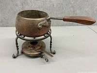 Side angle photo of the set showing pot handle, burner and metal stand