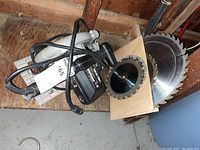 Porter Cable circular saw with attached power cord and several extra saw blades on cardboard.