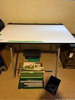 Full view of the drafting table with drafting tools arranged below it showing the table size and setup