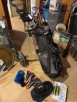 Full view of golf cart with golf bag filled with clubs, covers, and golf balls.