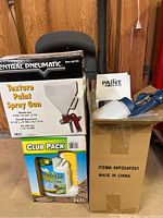 Photo of boxed Central Pneumatic Texture Paint Spray Gun, Hose Storage reel handle visible, Paint Zoom sprayer and Club Pack of Pathclear liquid.