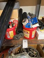 Black PVC pipes, copper pipe fittings in Folgers coffee containers, various boxed parts on a basement shelf.