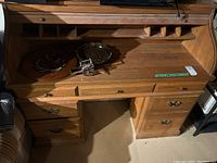 Front and interior view of the secretary desk showing the fold-down writing surface with compartments and decorative items on top.