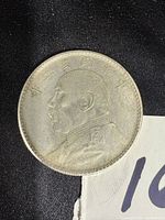 Obverse side of the 1914 Chinese Yuan Shih Kai silver dollar coin showing portrait and Chinese characters.