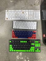 Four keyboards laid out on floor showing various sizes and colors; some missing keys.