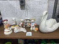 Overview of all Lenox animal figurines and swan bowl on wooden shelf showing arrangement and condition.