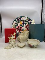 Full grouping of Lenox holiday pieces including plate, sleigh, bowl, dinosaur figurine, Grinch music box, and a small ceramic bell, displayed together.