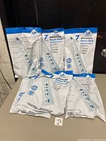 Six unopened bags of MoreLite Advanced 7-Outlet Power Strips stacked against a wall.