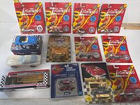 Full lot of Johnny Lightning die-cast toy cars mostly new in packaging, arranged on flat surface.